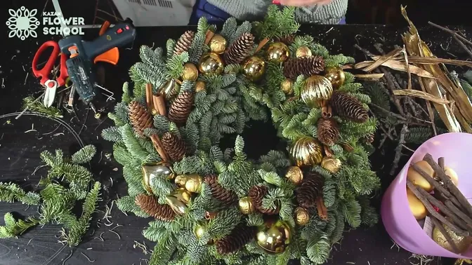 Cones and warm gold details arranged among clockwise fir branches