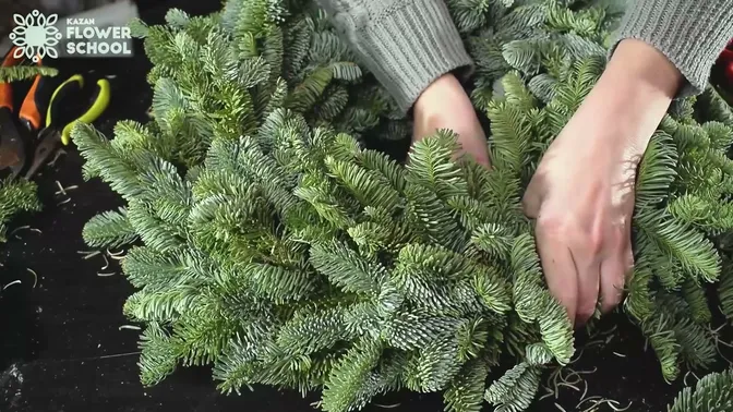The last fir layer being tucked beneath the first at the wreath join