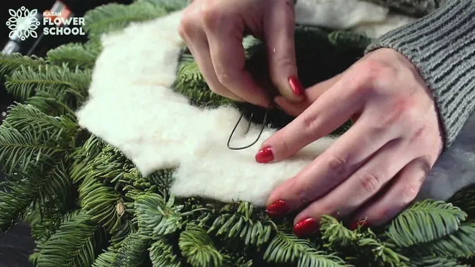 Folded wire hook fixed through the felt-covered back of the wreath
