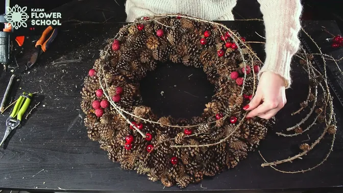 Slender larch branches laid around the cone-covered wreath
