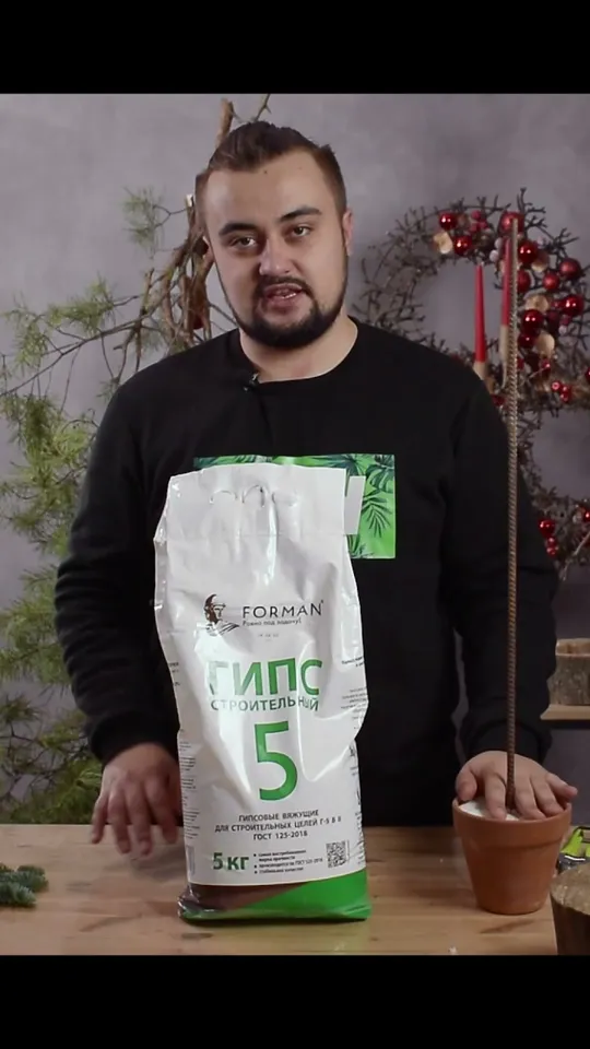 A bag of building plaster beside the prepared pot and rod