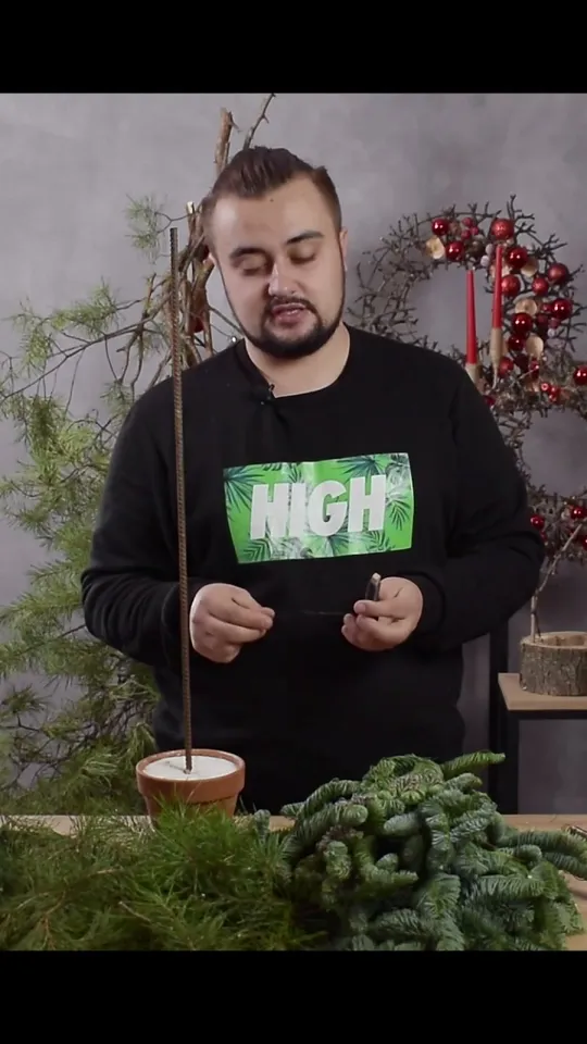 Binding wire held above the prepared greenery and the potted rod