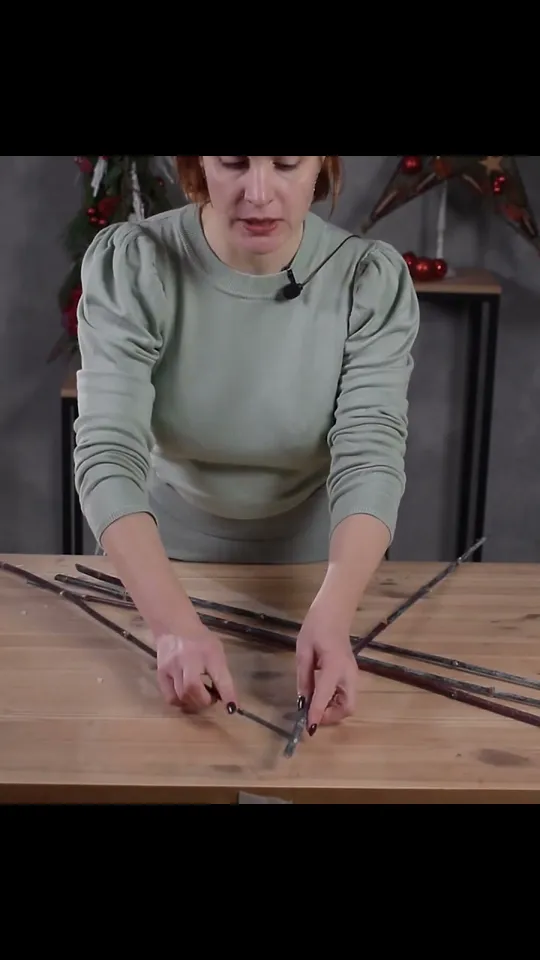 Five long twigs being arranged on the table for a star frame