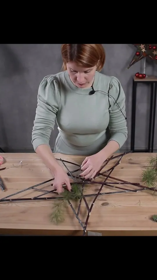Pine sprigs being placed between the branches of the star