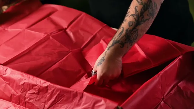 Red tissue paper spread inside a gift box, with the edges extending over the sides