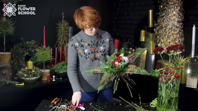 Red and pink flowers gathering in the middle of the fir-covered star while the stems are held below it.