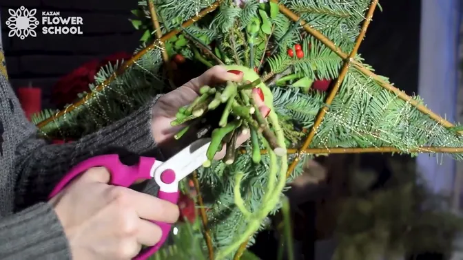 The tied stems below the star, wrapped with green felt cord and being trimmed with pruners.