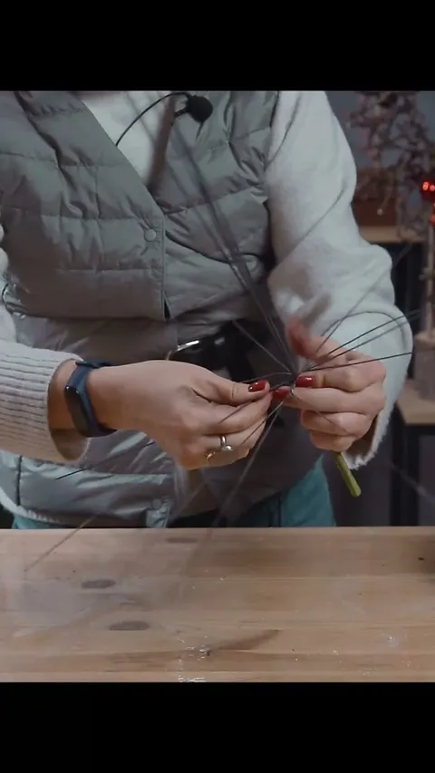 Pairs of wire being twisted above a taped handle, with the free ends spreading outward.