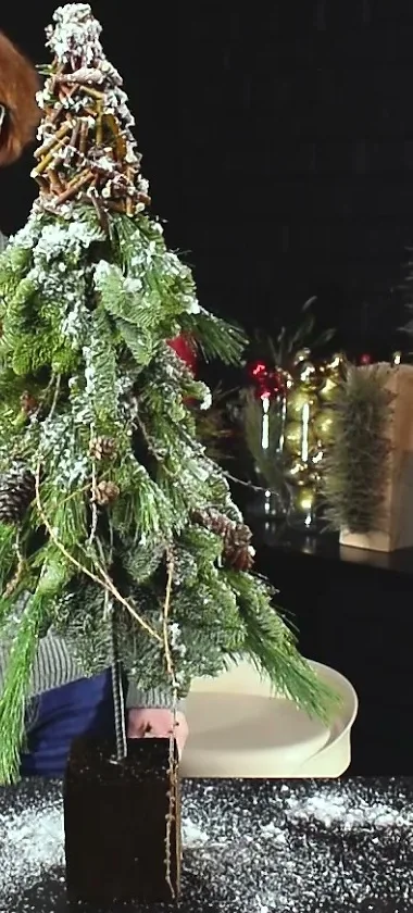 Tall fir tree decorated with twig garlands and a snowy finish on a dark rectangular base.