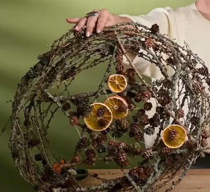 Open twig wreath with dried orange slices, pinecones and a six-pointed star.