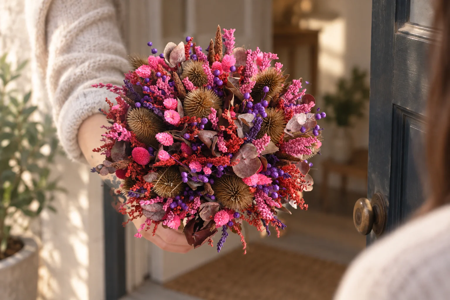 Round pink and purple dried flower bouquet in a styled setting